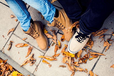 person wearing pair of brown lace-up shoes surrounded by gray pavement thumbnail