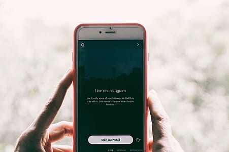 person holding iPhone displaying live on Instagram thumbnail