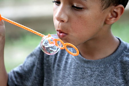 boy playing bubbles in orange plastic stick thumbnail