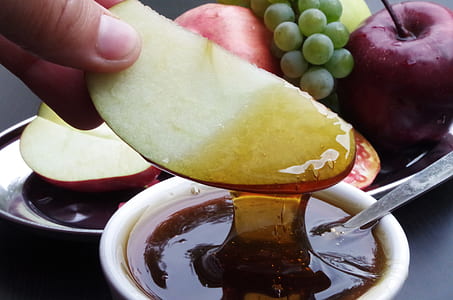person dipping apple slice in honey thumbnail