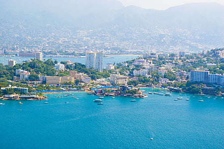 aerial view of city buildings near body of water thumbnail
