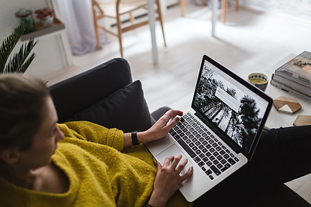 Young woman sitting on the sofa and working on her laptop thumbnail