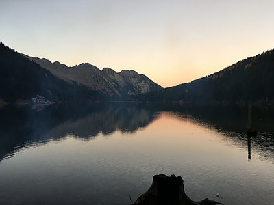body of water against silhouette image of mountain hill thumbnail