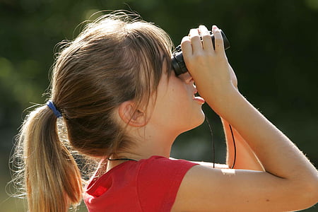 woman holding binoculars while looking up thumbnail