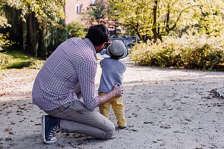 man kneeling on one knee holding toddler thumbnail