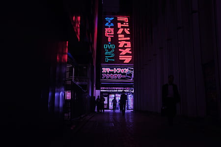 people walking on hallway between buildings with LED signages thumbnail