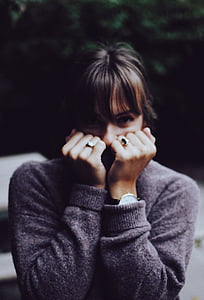 woman wearing sweater covering her face thumbnail