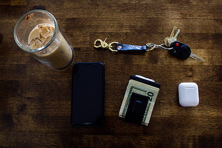 flat lay photogrphy of AirPods, key, wallet, and phone on table thumbnail