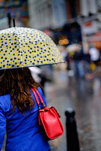 panning photography of woman in blue top holding umbrella thumbnail