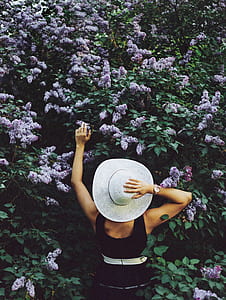 woman in black holding purple cluster flower during daytime thumbnail