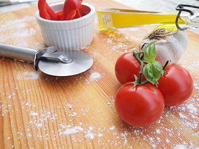 tomatoes beside garlic and pizza slicer thumbnail