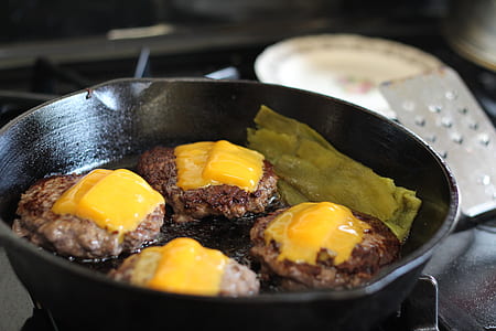 four fried foods with cheese on top in round black pot thumbnail