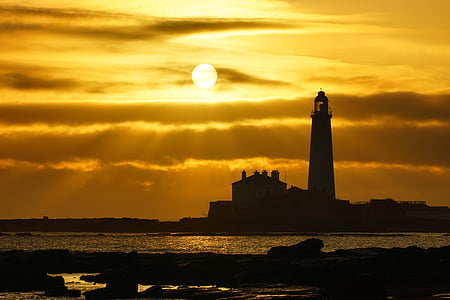 lighthouse beside body of water during sunset thumbnail