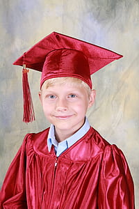 smiling boy wearing red silk academic gown and mortar board thumbnail