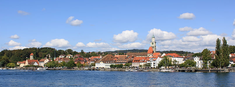 orange and white building surrounded by trees beside body of water thumbnail