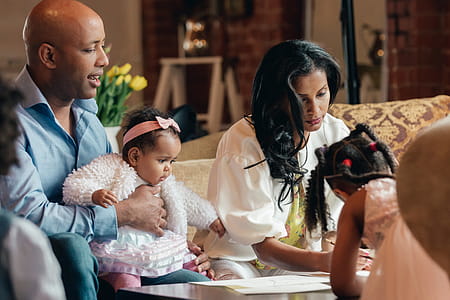Parents And Two Daughters In Family Room Photo thumbnail