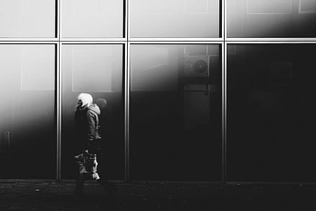 grayscale photo of person walking along street thumbnail