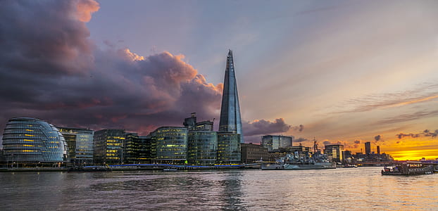 city buildings near body of water under cloudy sky at daytime thumbnail