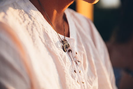 A young Caucasian man wearing ring in a neckchain at sunset thumbnail