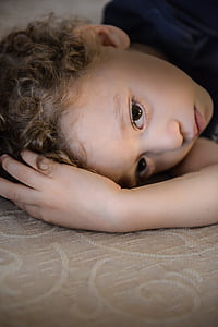 toddler lying on brown floral textile thumbnail