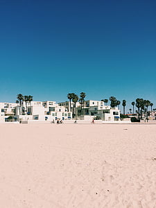 white concrete houses with trees under blue sky thumbnail