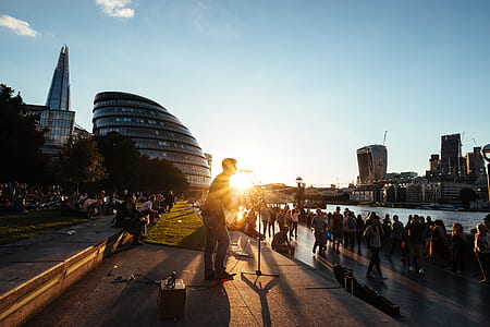 silhouette of man standing beside crowd in front of body of water thumbnail