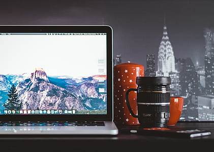 MacBook Pro on table beside telephoto lens mug thumbnail