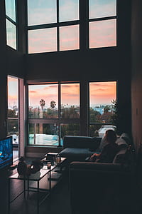 woman sitting on gray sectional couch looki outside thumbnail