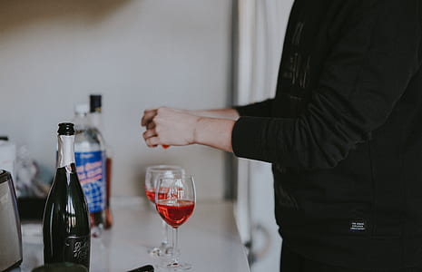 person standing in front of wine glasses thumbnail