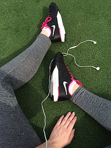 person sitting on green surface with white earphones on floor thumbnail