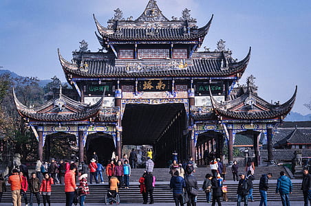 group of people standing in front of pagoda structure thumbnail
