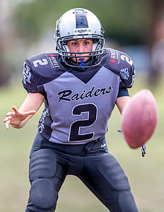 woman wearing football gear catching ball selective focus photography thumbnail