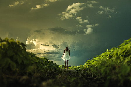 Women in white dress under clouds in the landscape thumbnail