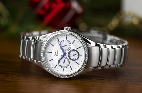 silver-colored clear gemstone encrusted chronograph watch with link bracelet placed on tabletop thumbnail