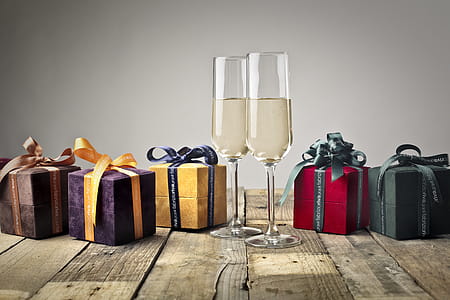 Five Assorted-color Gift Boxes and Two Footed Glasses on Top of Table thumbnail