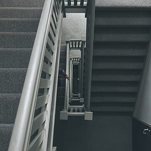 high angle photography of white wooden spiral stairs thumbnail