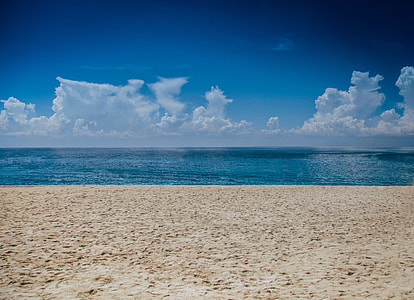 beach beside wide body of water horizon during daytime thumbnail