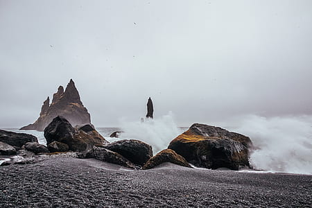 black and brown stones beside sea waves during daytime thumbnail