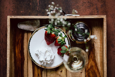 Strawberries with cream and glass of white wine on wooden tray thumbnail