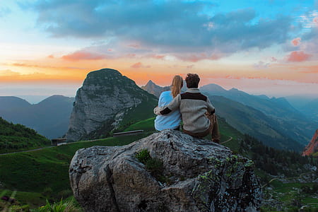man and woman on top of rock looking at sunset thumbnail