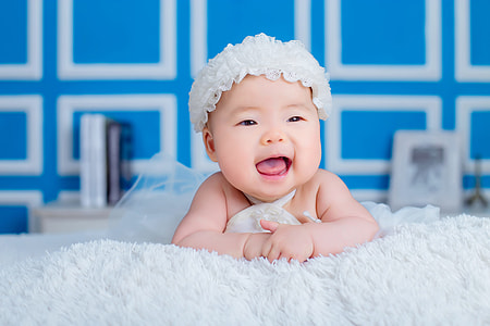 baby lying on white mattress thumbnail