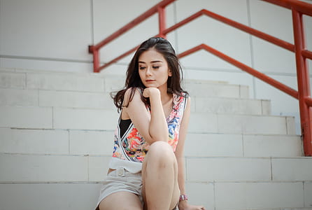 woman wearing floral tank top sitting on ladder thumbnail