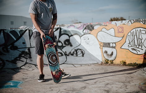 man holding skateboard on focus photo thumbnail