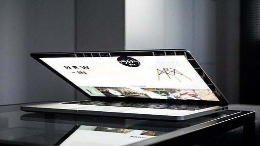 MacBook Pro turned-on on black wooden table thumbnail