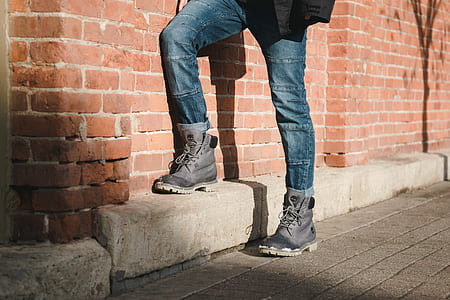 person wearing gray Timberland work boots standing near wall thumbnail