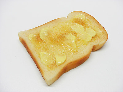 close-up photo of sliced bread with butter on white surface thumbnail