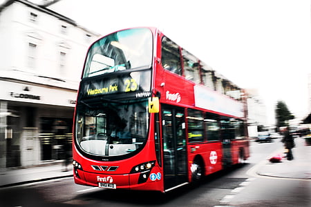 person standing in street near red bus thumbnail