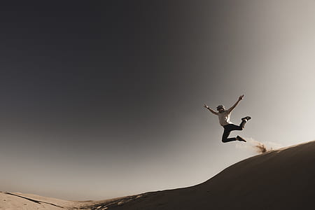 person jumping on beige sand thumbnail