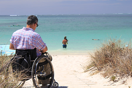 man sitting on wheelchair on seasire thumbnail