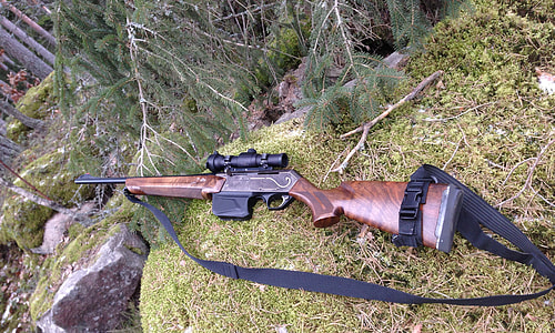 brown and black hunting rifle on ground thumbnail